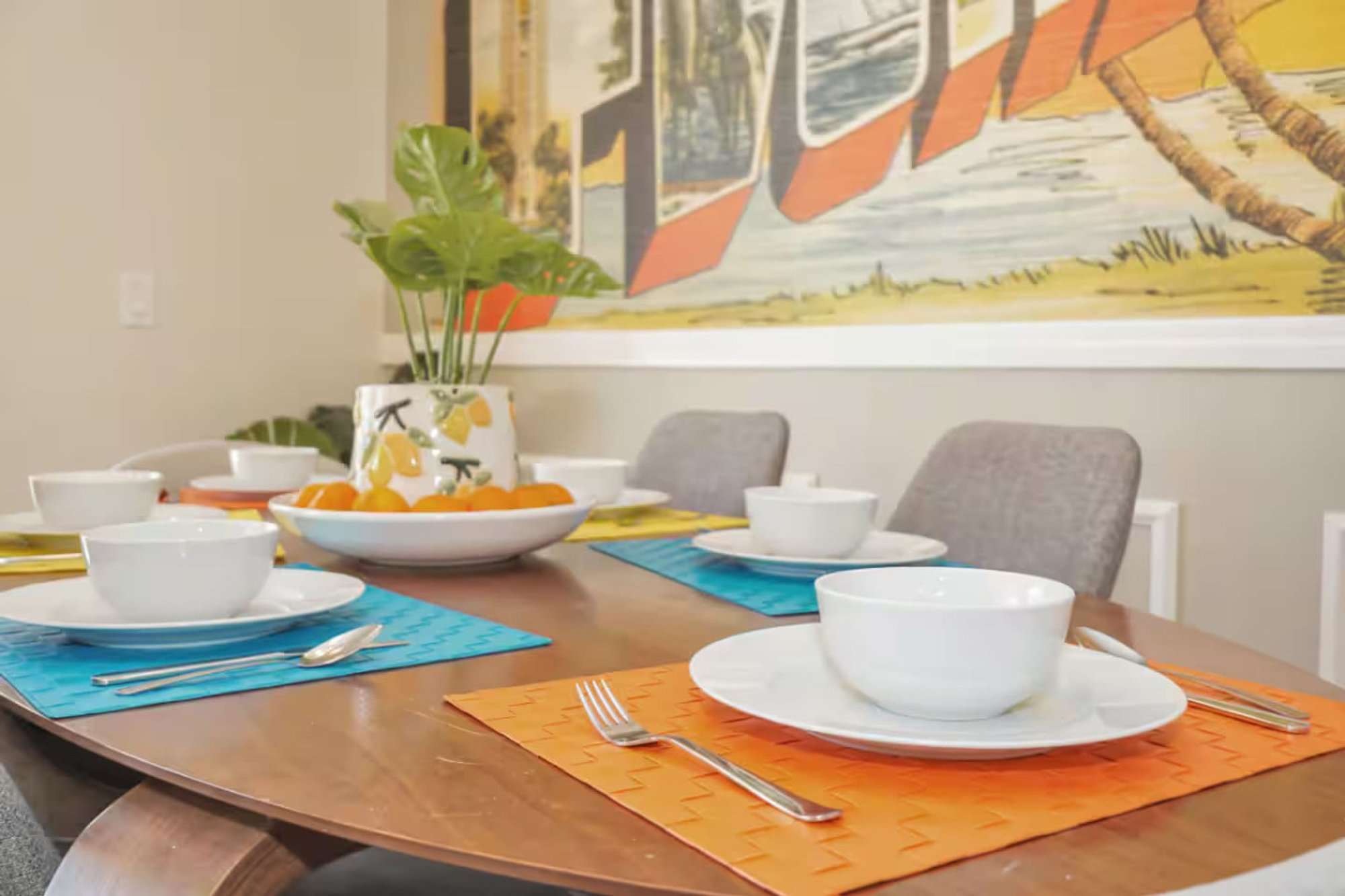 Dining table set for a meal under the wall mural