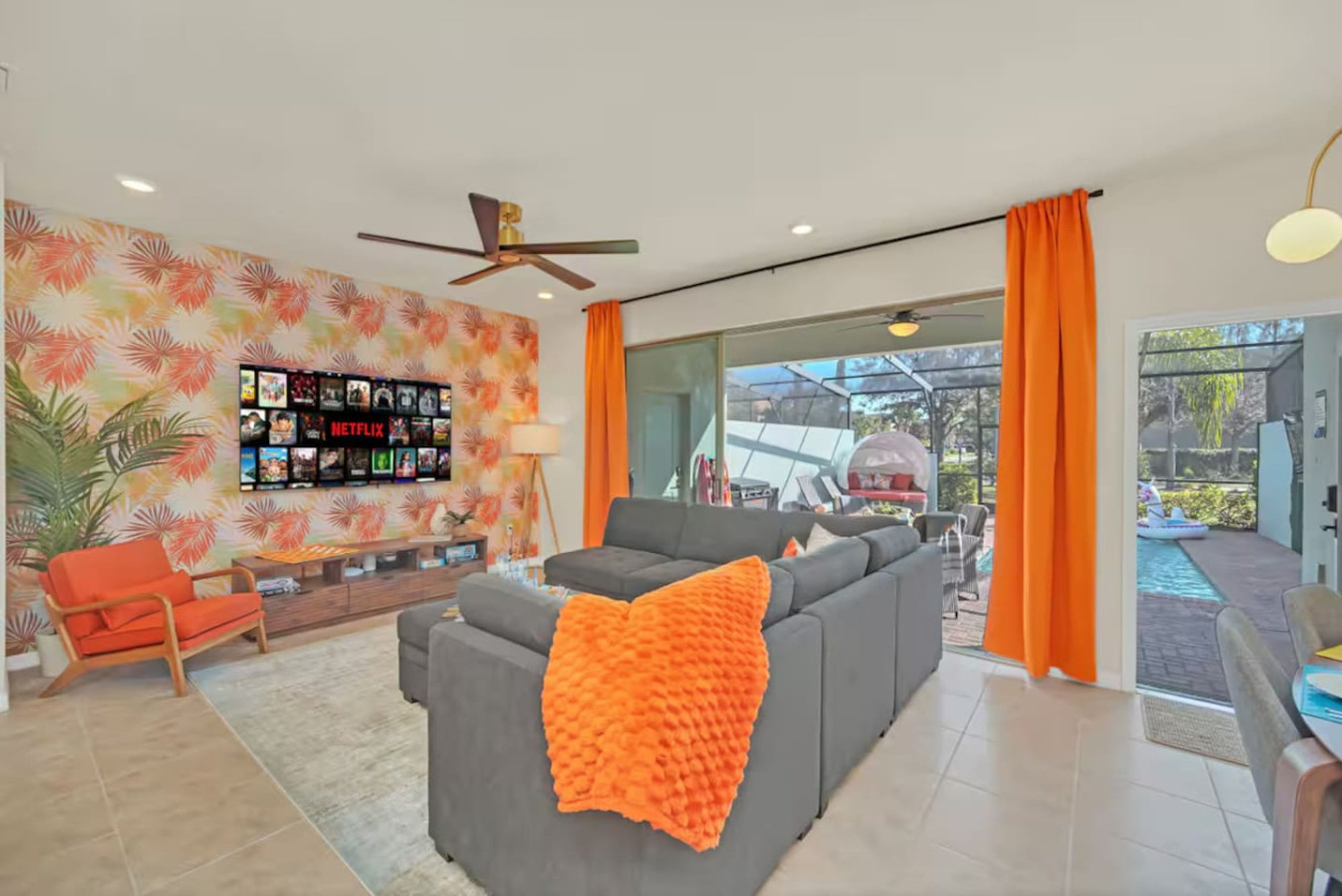 Living room with the orange curtains open to the pool lanai