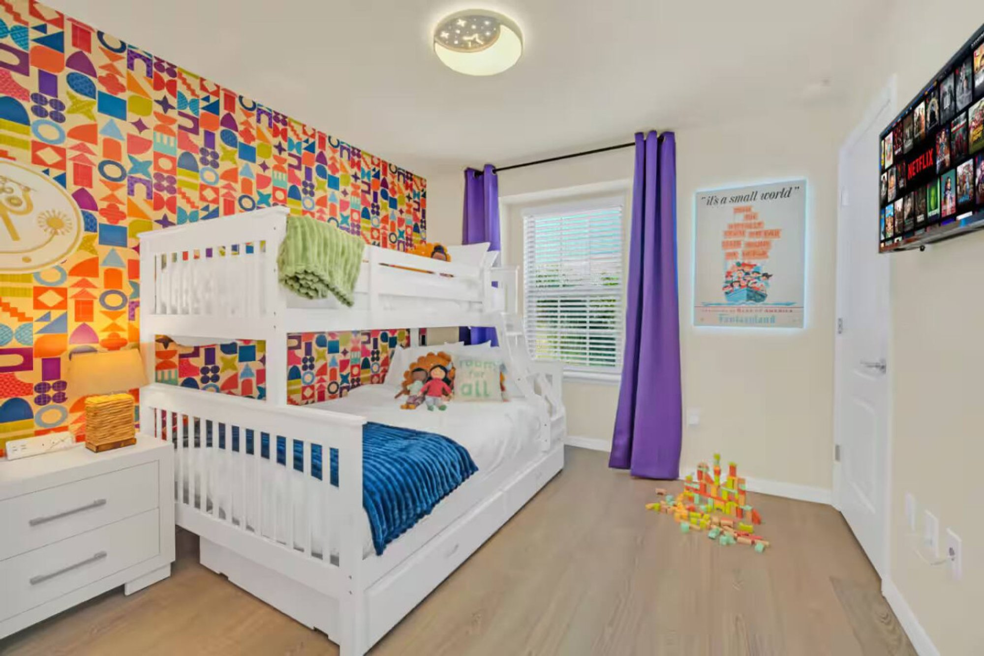 Bedroom 3, Small World theme: bunk beds against the geometric mural