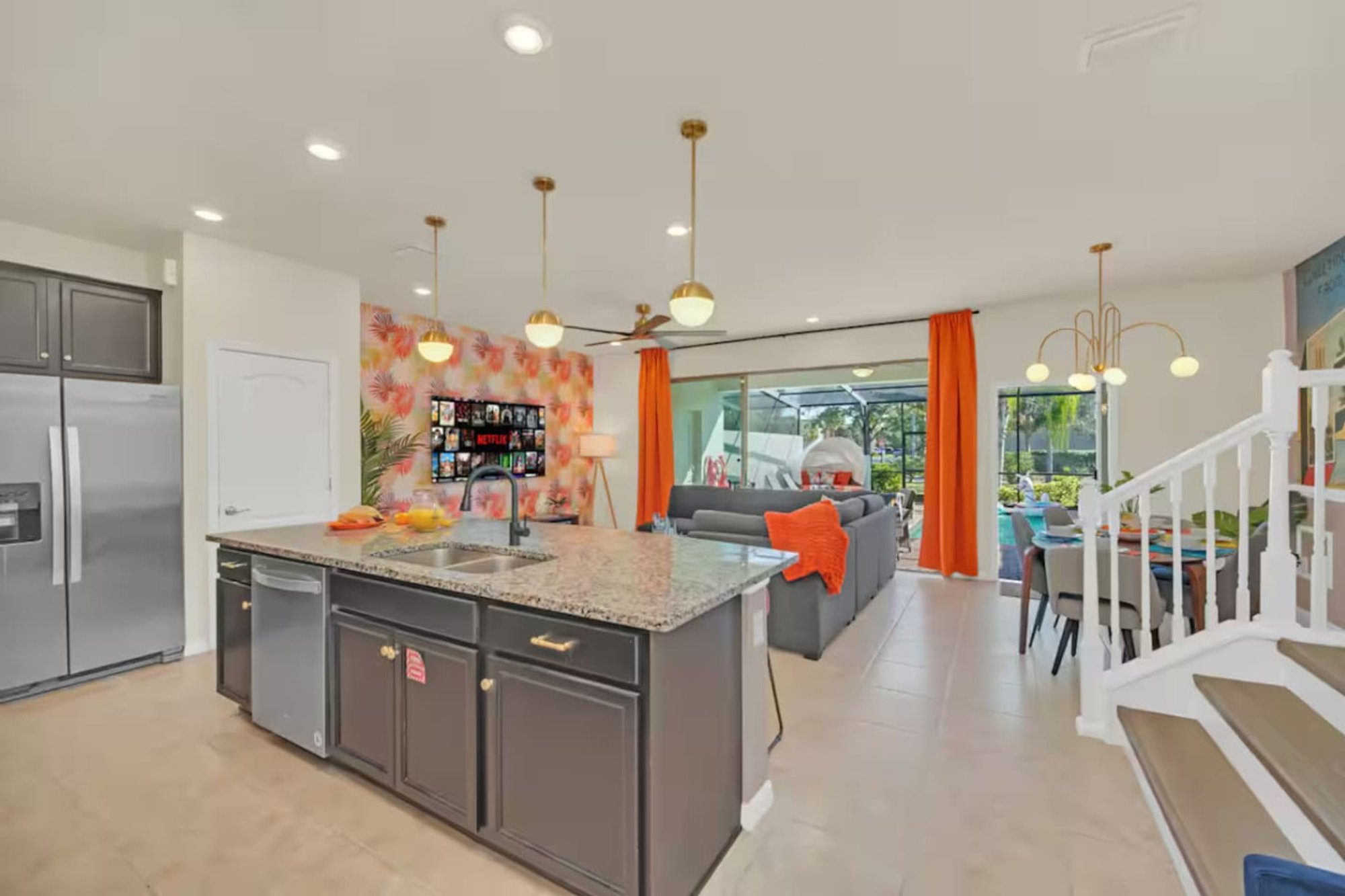 Kitchen island and stainless fridge, looking through to the stairs